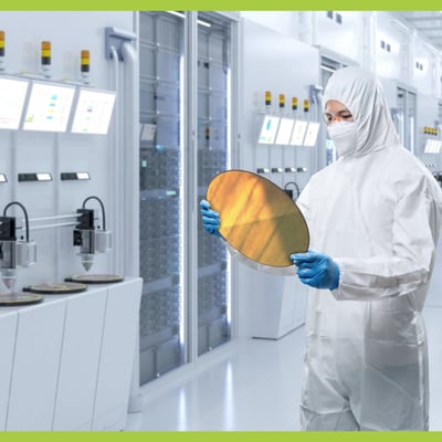 A person in a protective full body suit stands in a lab environment. They are holding a circle of reflective metal.