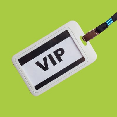 A white lanyard with a label that reads VIP on it against a green background