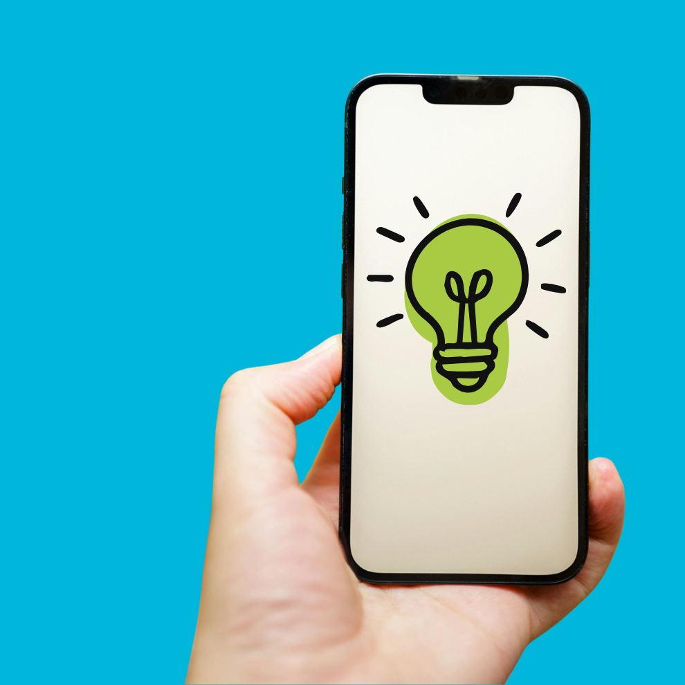 A hand holding a mobile phone, the phone has an icon of a lit up lightbulb on it